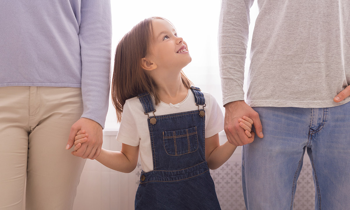 child holding hands with parents - Styles of Parenting